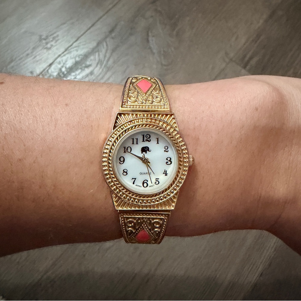 Francesca’s Gold Tone Filigree Bracelet Watch with Elephants and Coral Accents